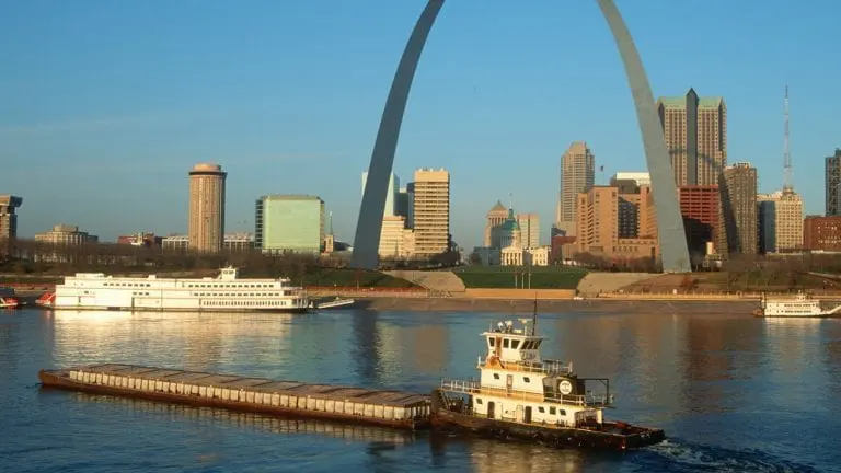 Remolcador empujando la barcaza frente al horizonte de St. Louis en Missouri