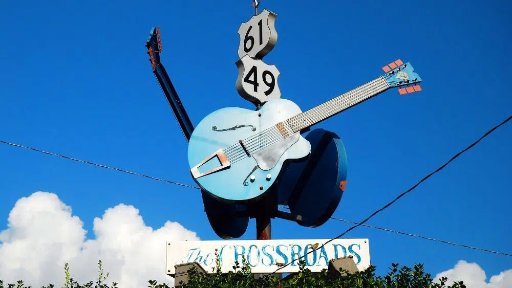 cartel gigante con una guitarra que dice "The Crossroads" debajo en Clarksdale, MS