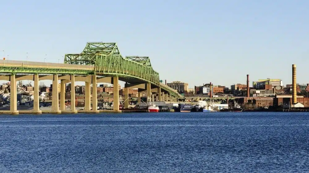 Un puente moderno que cruza un río y mira a la ciudad a través del río.