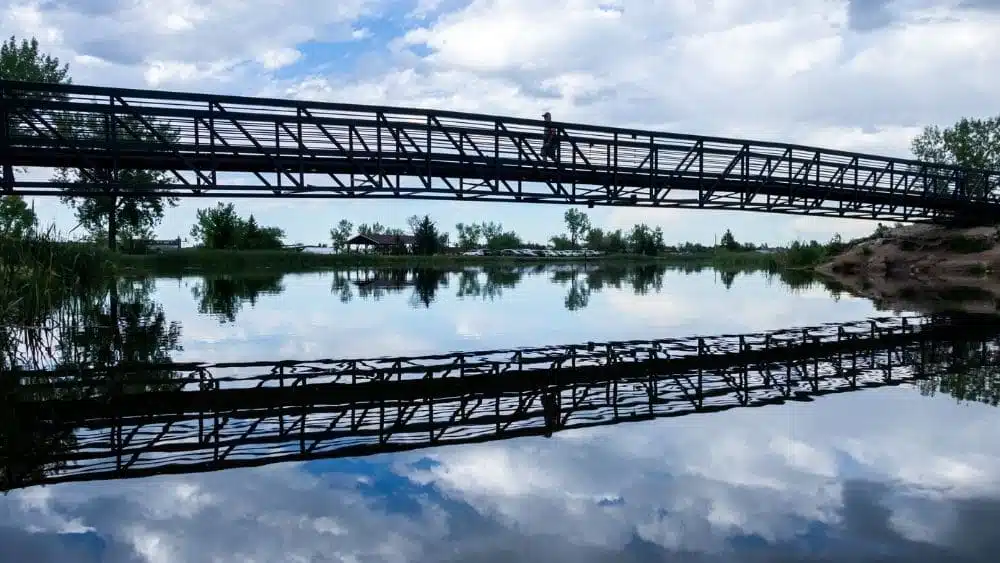 Puente de metal cerca de Gillette, Wyoming que se refleja claramente en el agua.