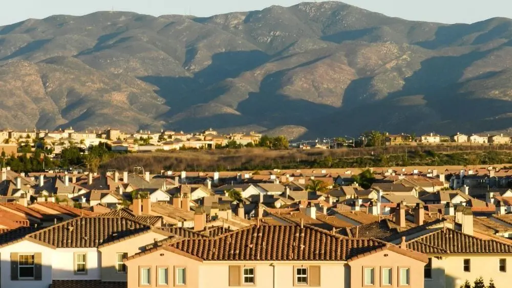 Vista aérea de casas de estilo español en un valle frente a una cordillera.
